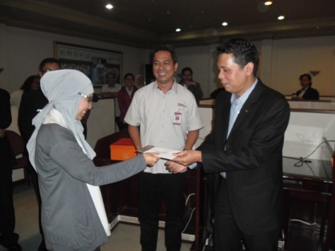 General Manager Algamar Idris presents a stay voucher to a lucky winner from Media Indonesia Daily Newspaper